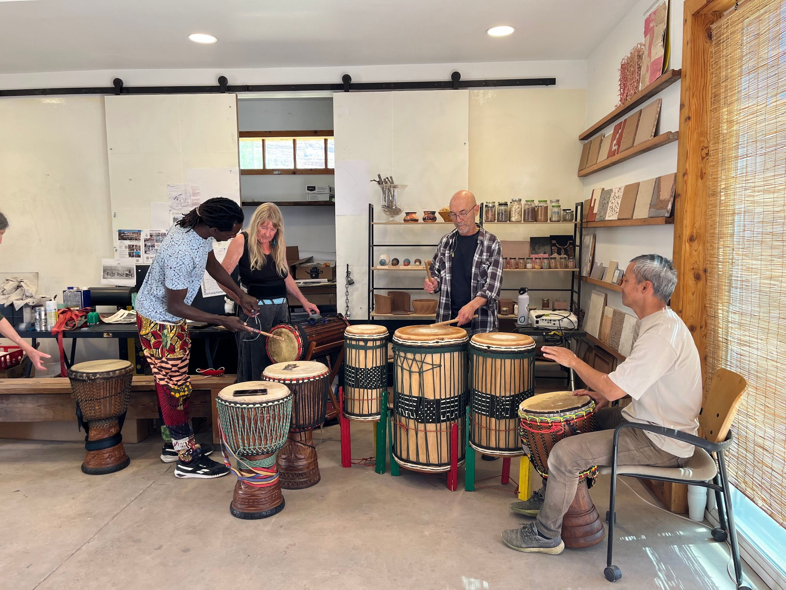 People playing drums in a workshop setting.