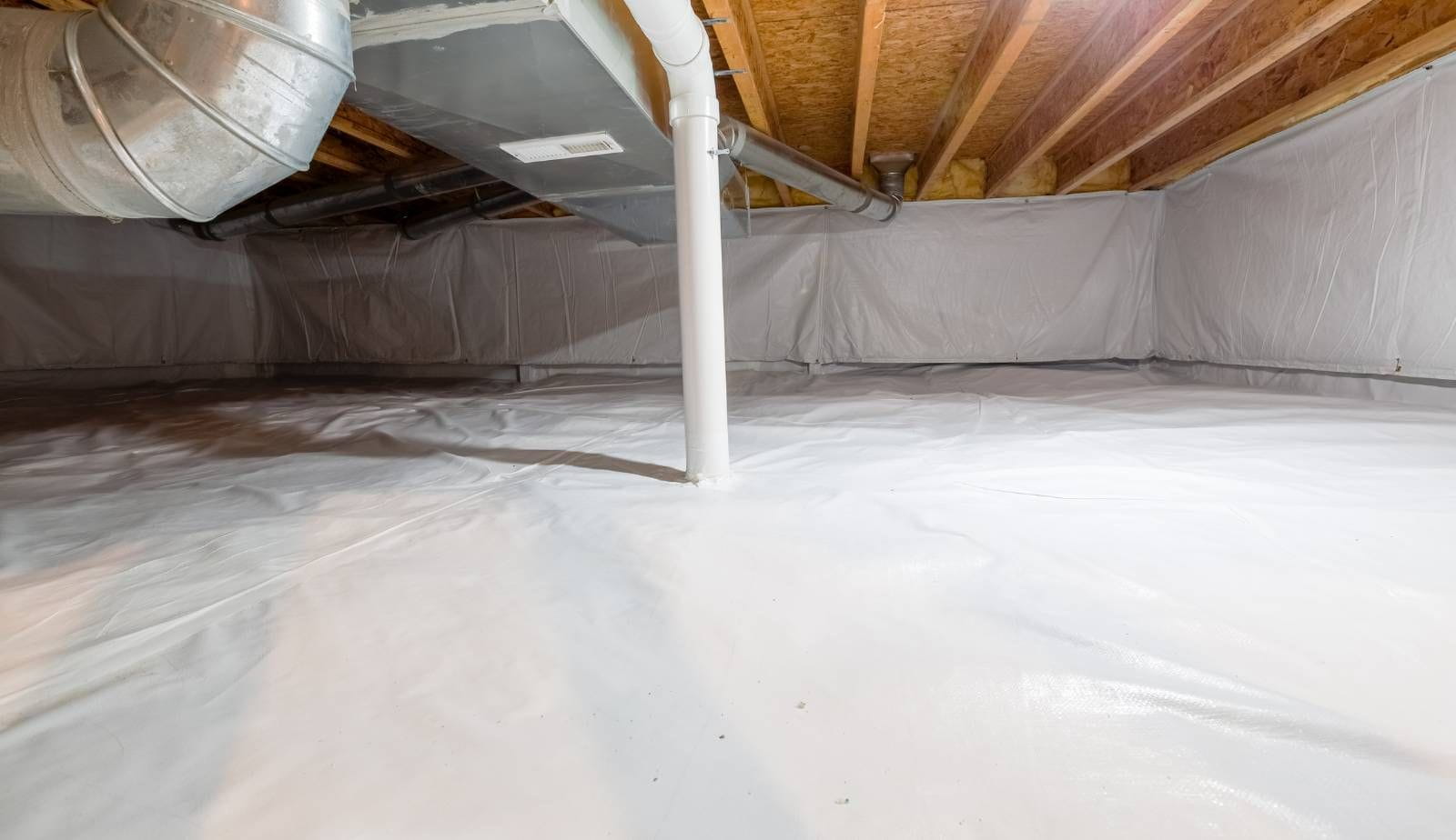 A Mastertech Environmental technician in protective gear performing mold remediation in a crawlspace.