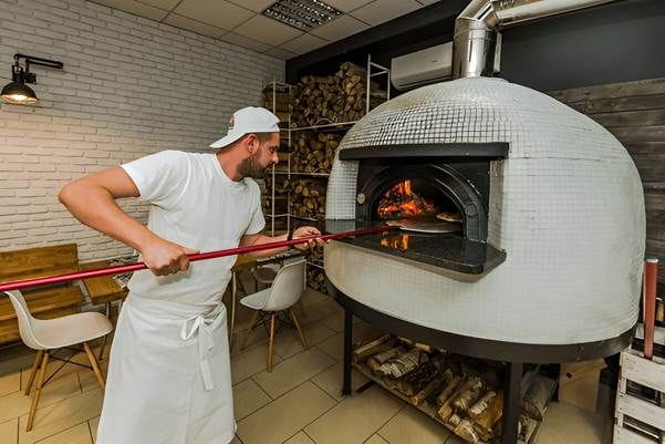 A person holding a red stick in front of a white oven AI-generated content may be incorrect.