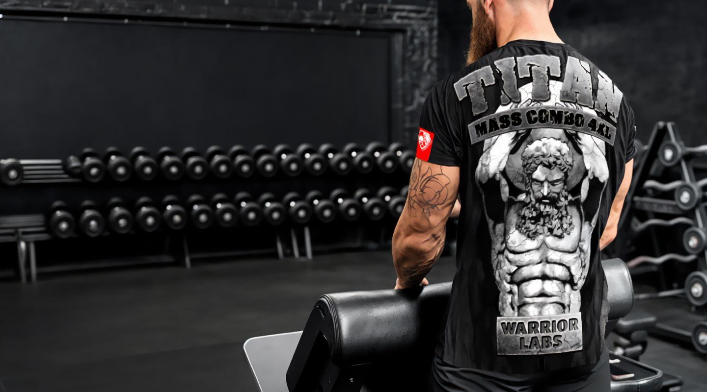 #5 - Muž stojí vo fitness centre v športovom tričku Titan s motívom sillného antického muža s dokonalými kockami na bruchu a veľkými svalnatými rukami