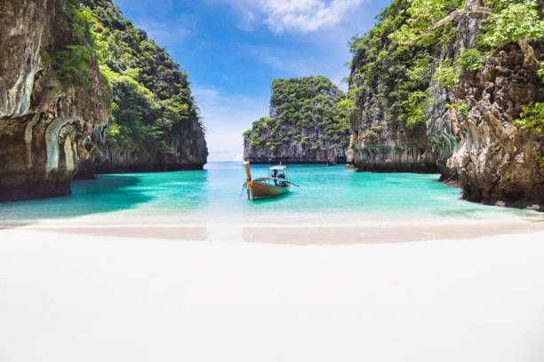 Thai traditional wooden longtail boat and beautiful beach in Phuket province, Thailand. The Thai traditional wooden longtail boat and beautiful beach in Phuket province, Thailand. thailand beach stock pictures, royalty-free photos & images