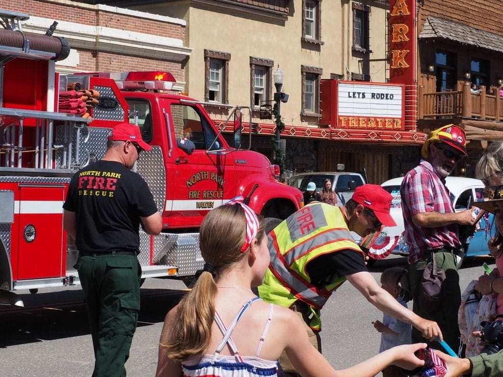 North Park Fire Rescue during the Never Summer Rodeo Parade handing out candy to kids in attendance