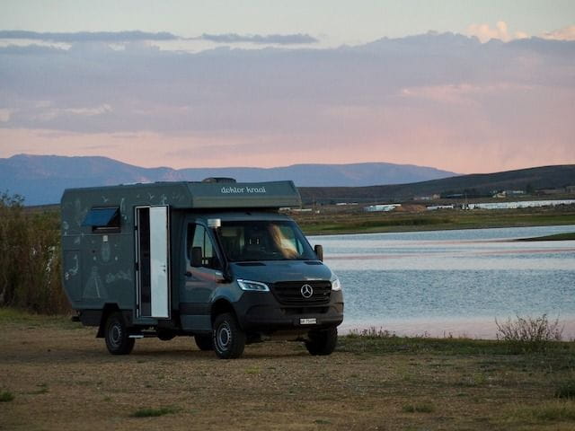 A small Mercedes conversion van boondocker camped by the Walden Reservoir at sunset