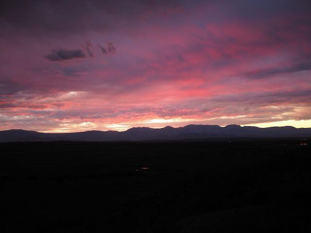 sunset view of the Park Range with purple clouds and mountains silouetted in the distance