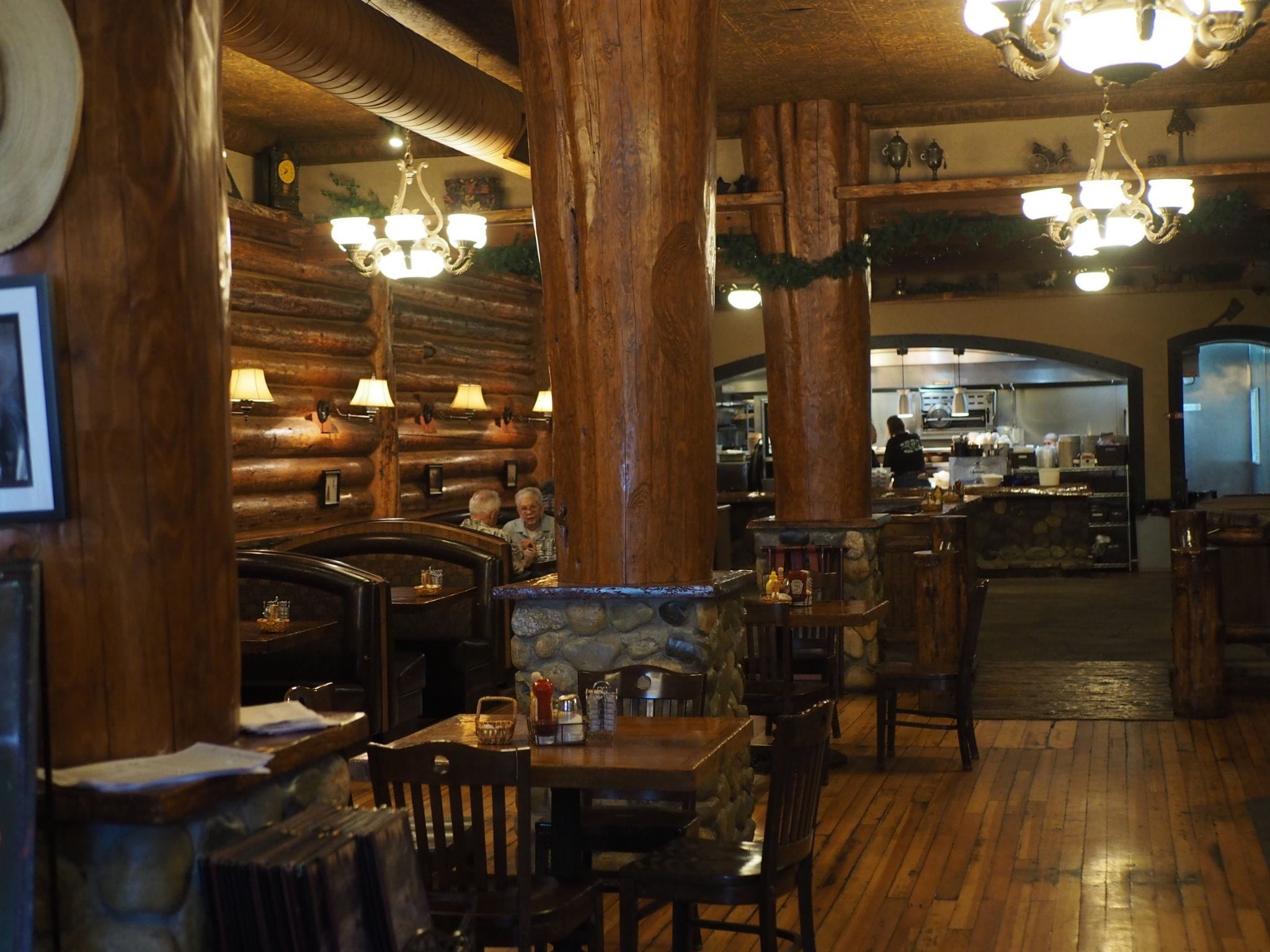 Interior view of Walden's River Rock. A sit down restaurant with a hewn log interior, rustic chandeliers, and warm local vibe.