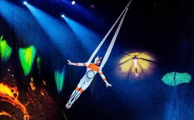 A person in a white suit flying in the air

Description automatically generated