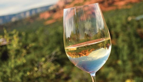A wine glass with Sedona red rocks reflected in the wine