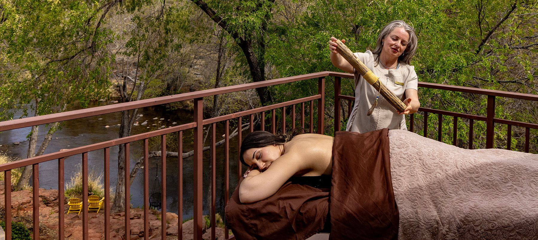 A woman receives a relaxing healing treatment while lying outside near Oak Creek.