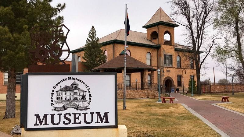 a sign reads, "Navajo County Historical Society Museum" in front of a historic building