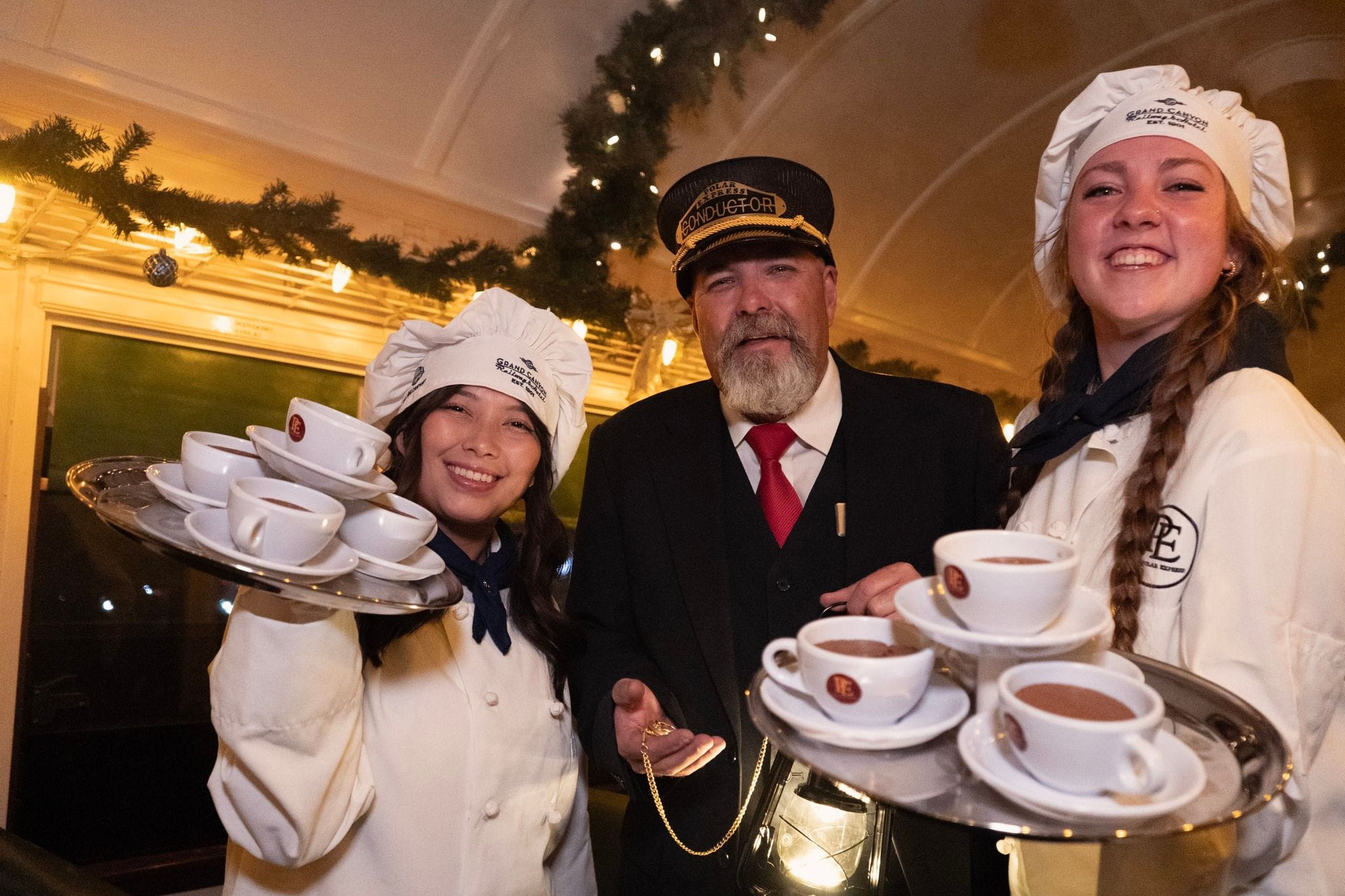 two servers and a conductor on a train